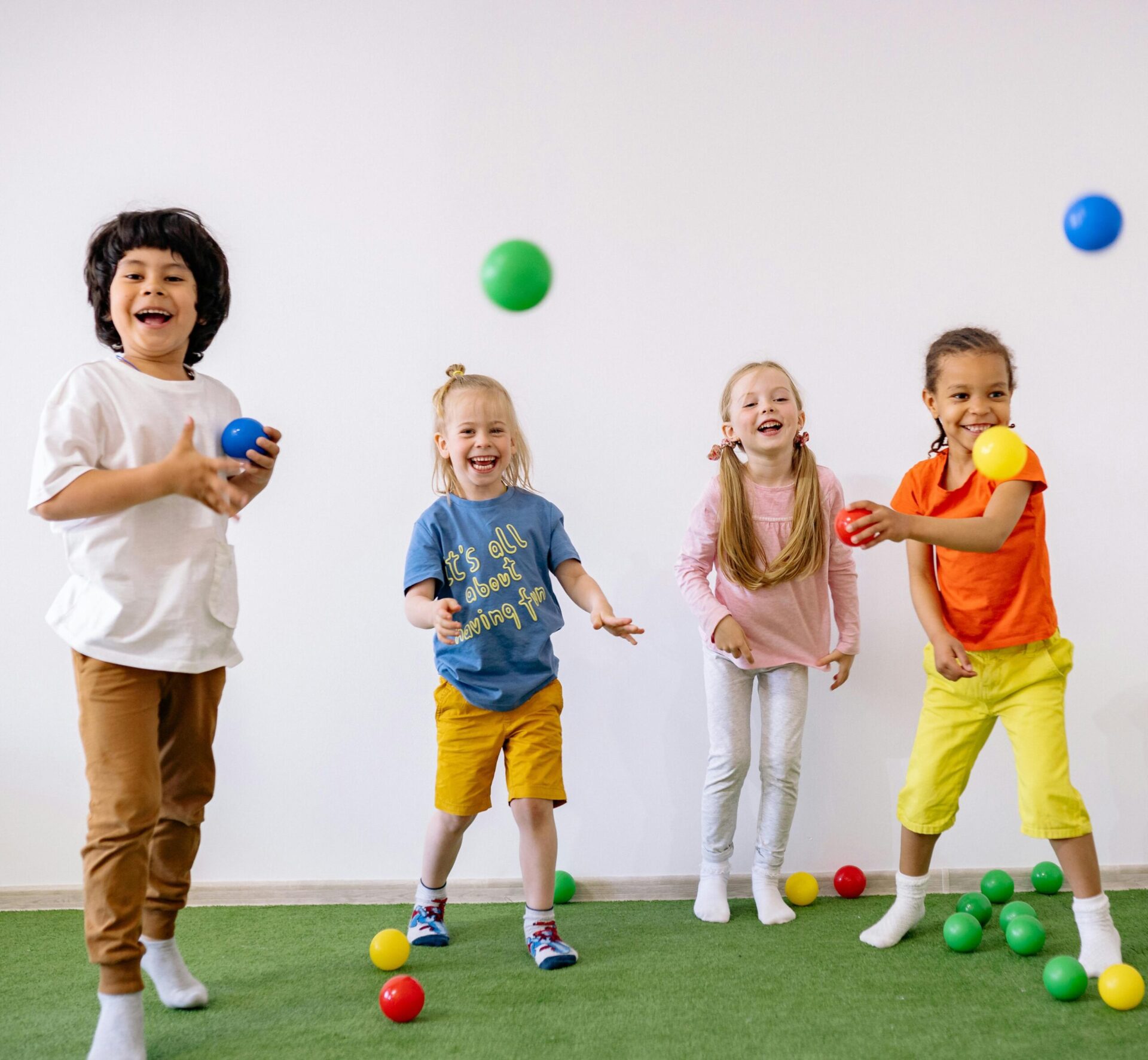Group of children smiling and playing with balls